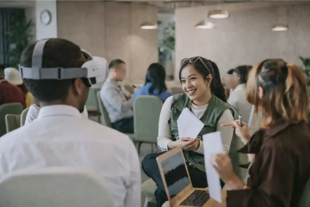 Activité de team building où une personne équipée d’un casque VR est guidée et accompagnée par ses collègues